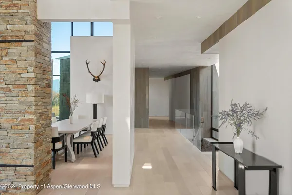 a dining room with furniture a large window and a kitchen view
