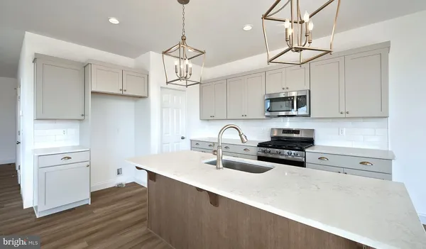 a kitchen with stainless steel appliances a stove center island and cabinets