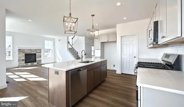 a kitchen with stainless steel appliances granite countertop a sink stove and a wooden floors
