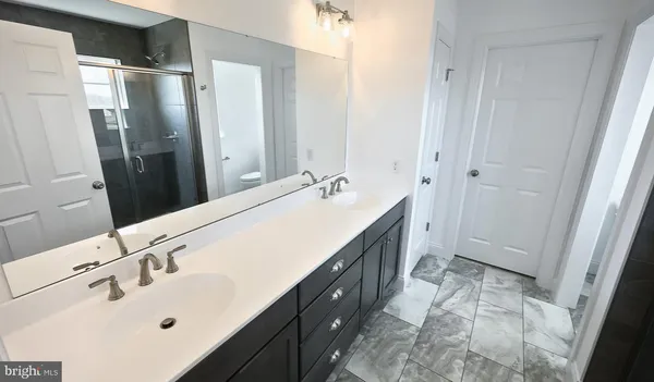a bathroom with a double vanity sink and mirror