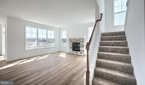 a view of empty room with wooden floor and fireplace