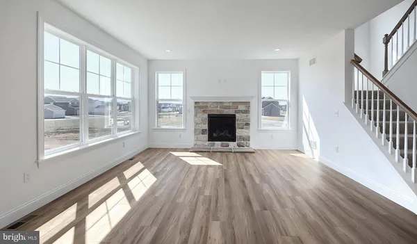 wooden floor fireplace and windows in an empty room