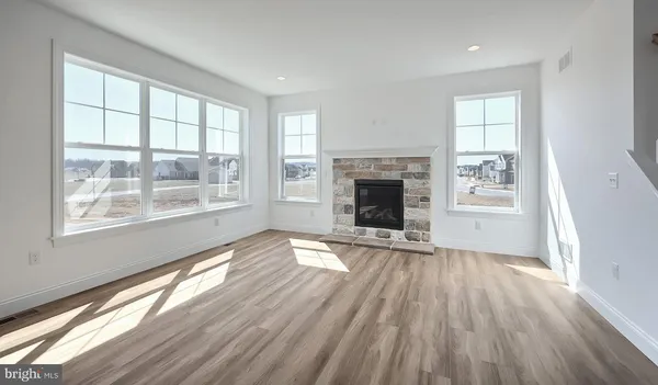 wooden floor fireplace and windows in an empty room
