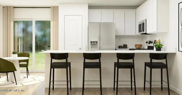 a kitchen with white cabinets and chairs