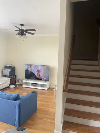 a view of living room with furniture and a ceiling fan