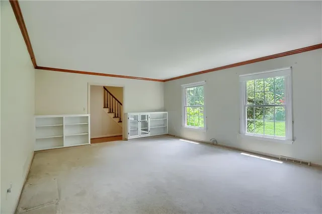 an empty room with a fireplace and window