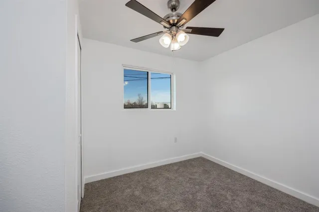 an empty room with a ceiling fan and a fan