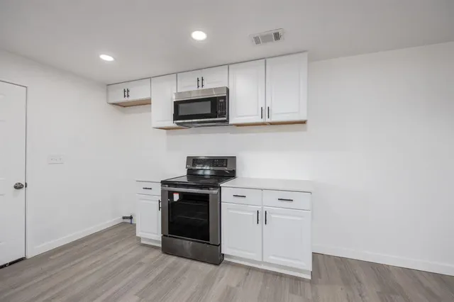 a view of cabinets a sink and wooden floor