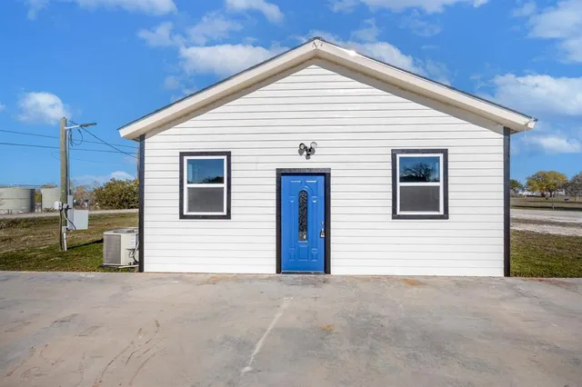 a view of an empty room with wooden floor ceiling fan