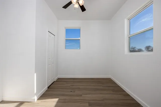 a view of empty room with wooden floor