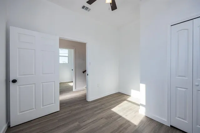 a view of an empty room with wooden floor and entryway