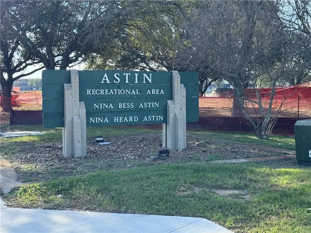 a sign board with tall trees