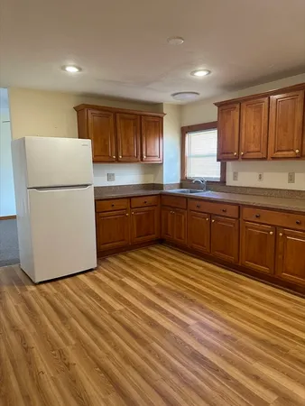 a kitchen with wooden cabinets and white appliances