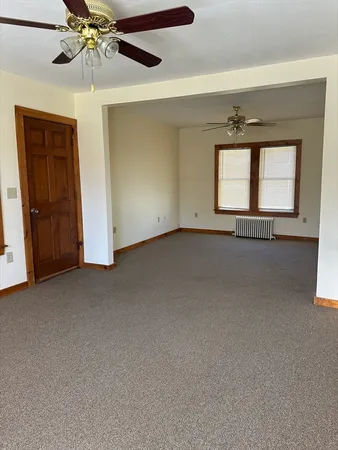 a view of a room that has a window and a ceiling fan