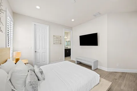 a bedroom with a bed and a flat screen tv