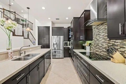a kitchen with stainless steel appliances granite countertop a sink and a refrigerator
