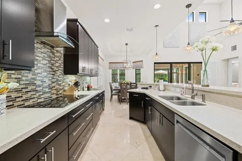 a kitchen with stainless steel appliances granite countertop sink stove and refrigerator
