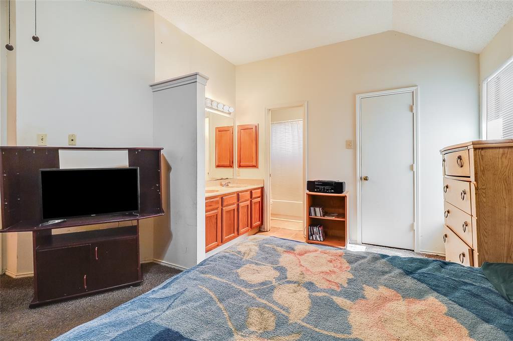 1728 Hackamore Street Mesquite, TX 75149 - Photo 10 of 22 Carpeted bedroom with vaulted ceiling, ensuite bathroom, and a textured ceiling