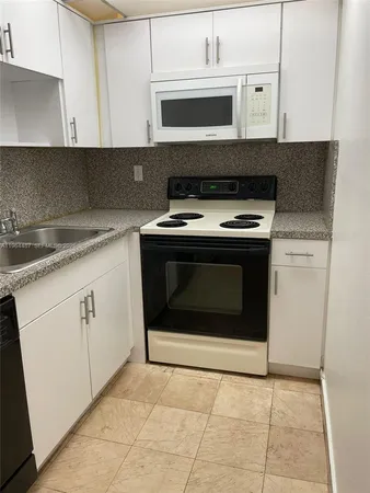 a stove top oven sitting inside of a kitchen
