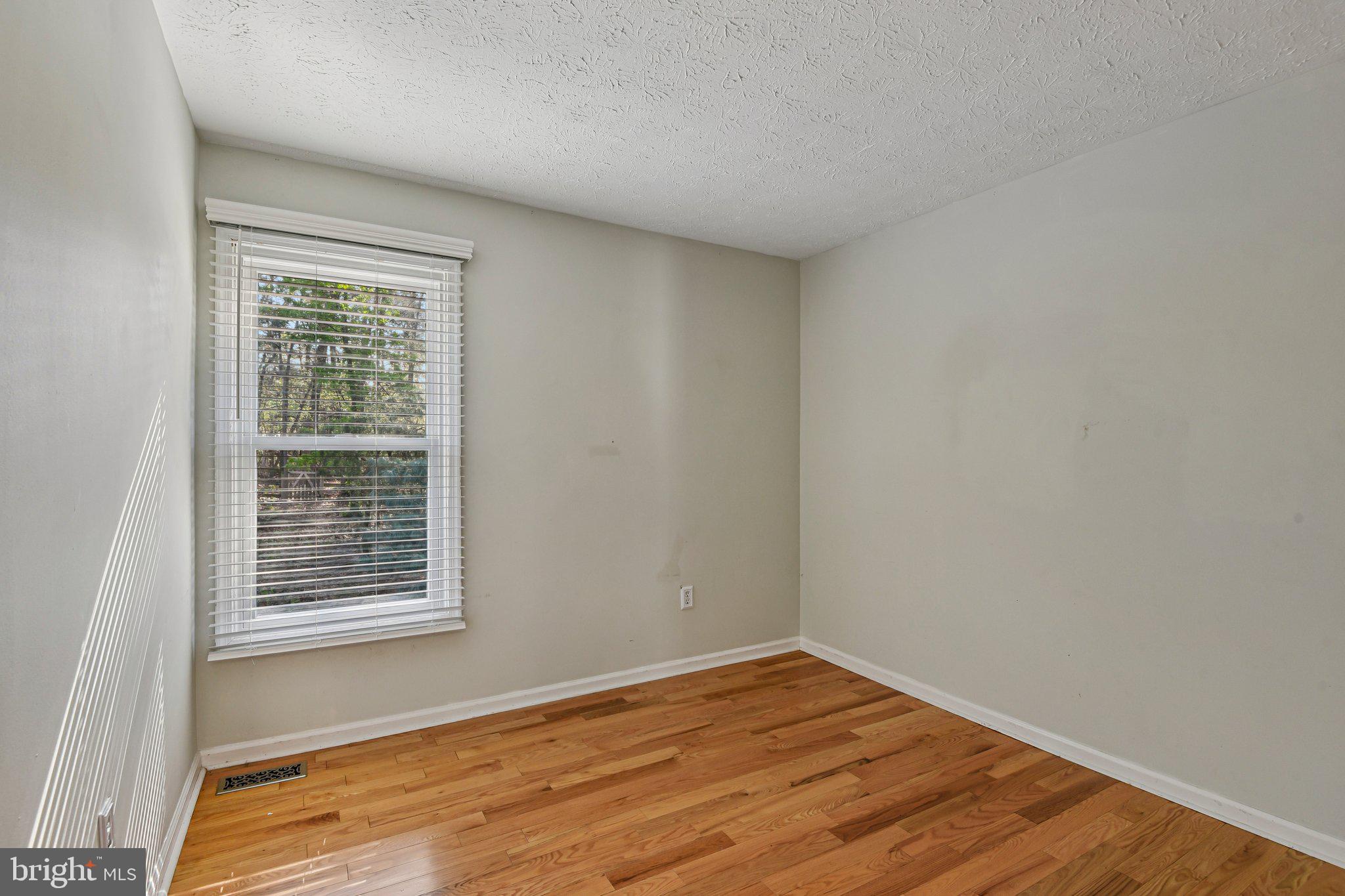 7617 Bear Forest Road Hanover, MD 21076 - Photo 16 of 37 a view of an empty room with wooden floor and a window