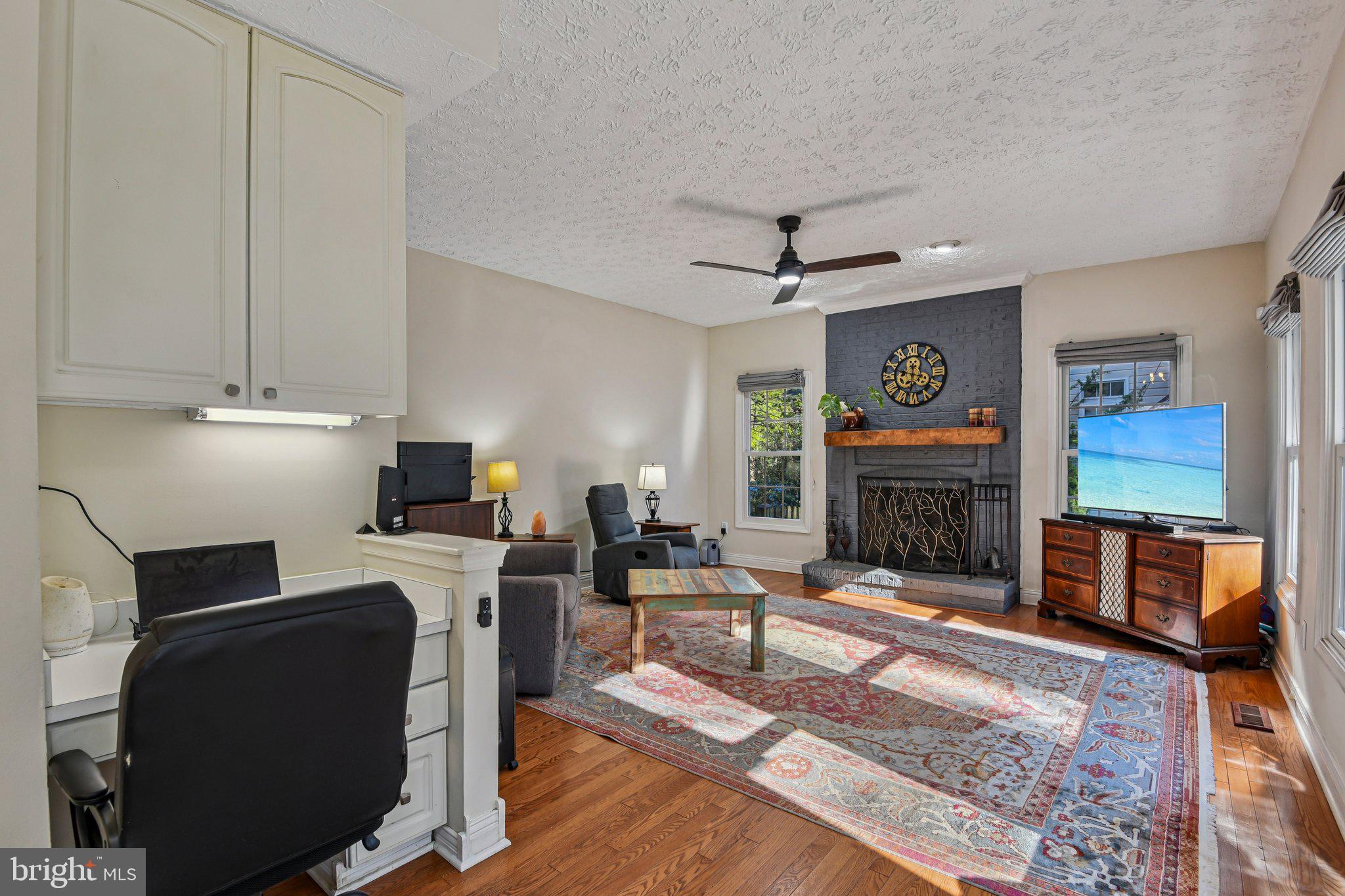 7617 Bear Forest Road Hanover, MD 21076 - Photo 10 of 37 a living room with furniture a fireplace and a flat screen tv