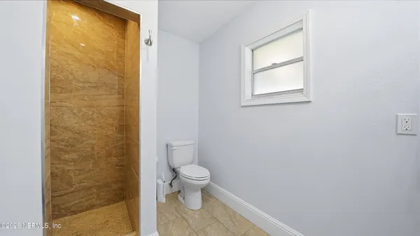 a bathroom with a granite countertop toilet and a shower