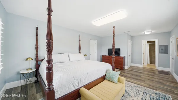 a bedroom with a bed and wooden floor