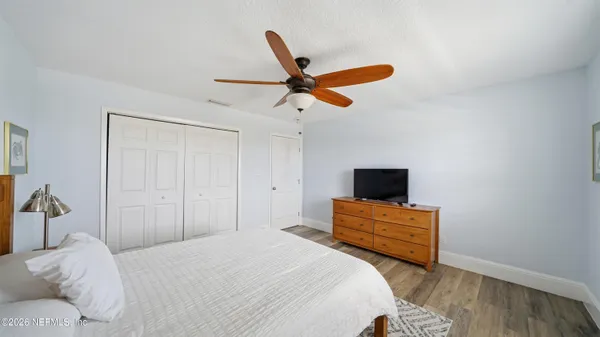 a bedroom with a bed and wooden floor