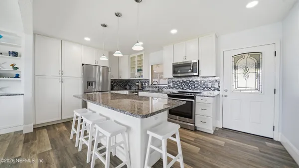 a kitchen with white cabinets and stainless steel appliances