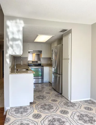 a kitchen with a refrigerator and a sink