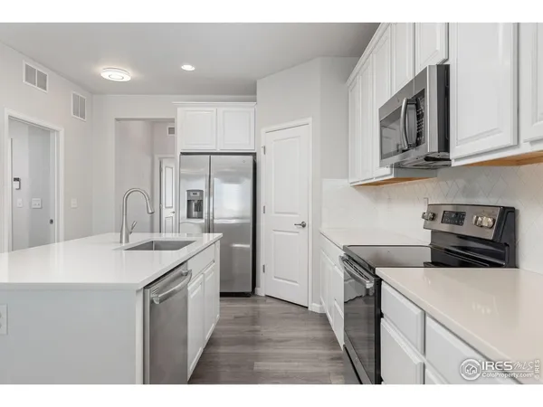 a kitchen with cabinets stainless steel appliances and a counter space