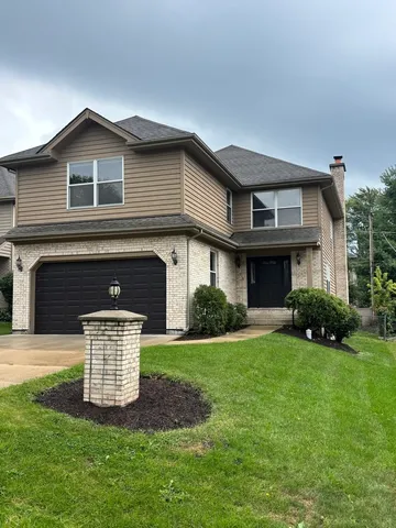 a front view of a house with a garden and yard