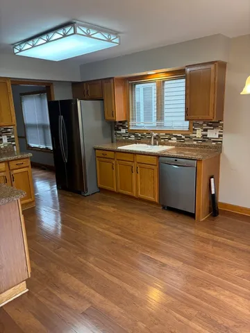a kitchen with stainless steel appliances granite countertop a stove a sink and a refrigerator