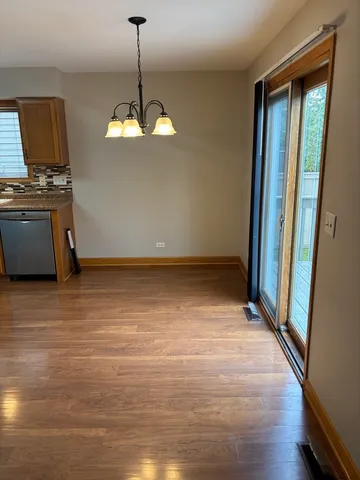 a view of a room with wooden floor and kitchen