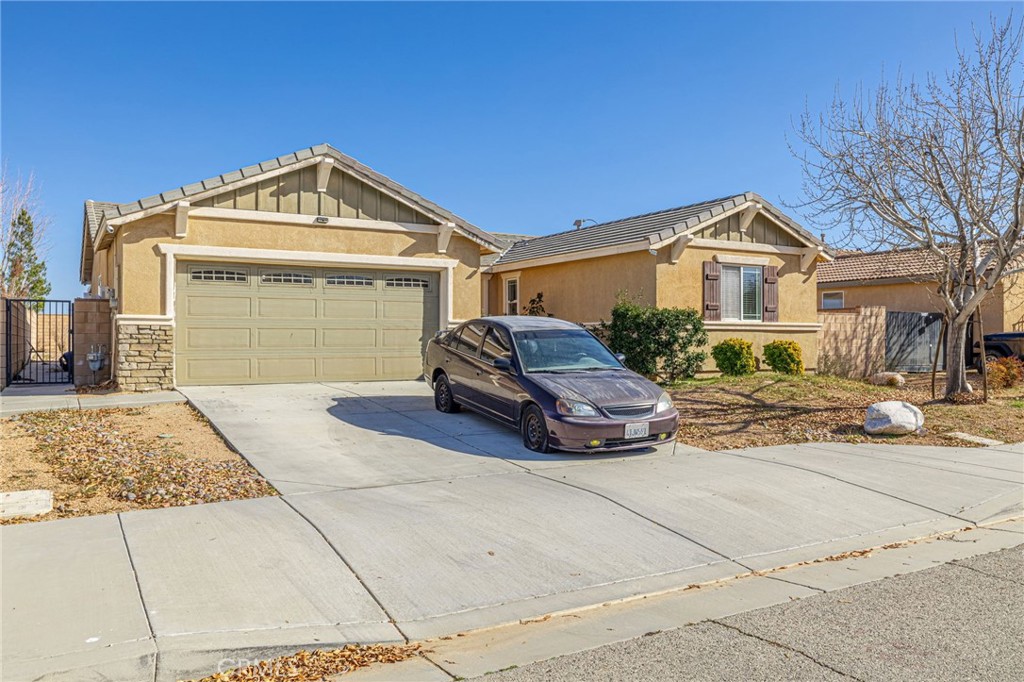 43128 Homestead Street Lancaster, CA 93535 - Photo 10 of 33 a front view of a house with a yard and garage