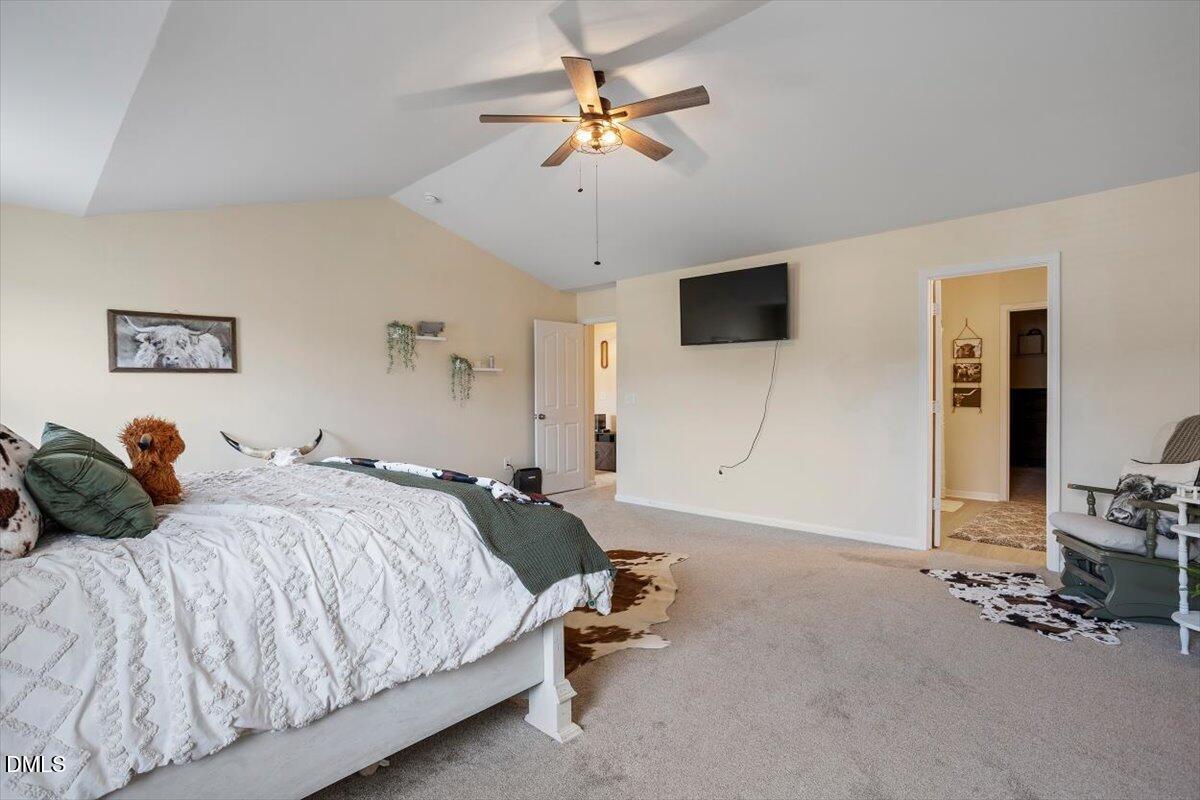 205 Battery Way Bunnlevel, NC 28323 - Photo 26 of 37 a bedroom with bed tv and a chandelier