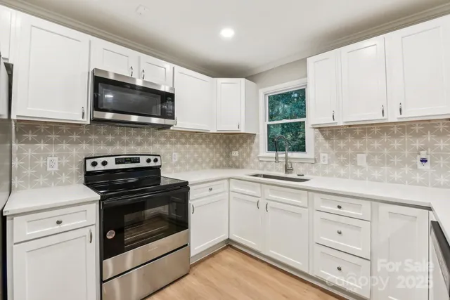 a kitchen with white cabinets and stainless steel appliances