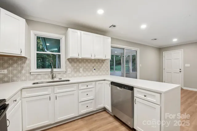 a kitchen with a sink window and cabinets