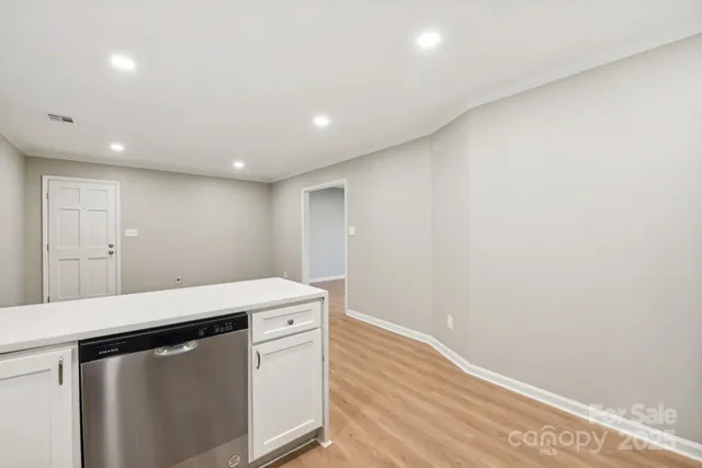 a kitchen with a wooden floor and white cabinets