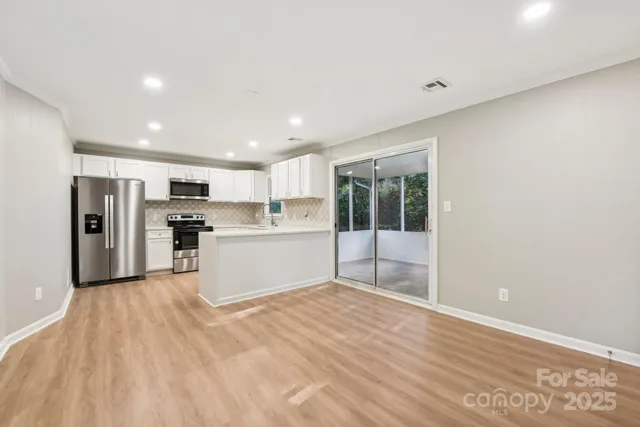 a view of kitchen with stainless steel appliances refrigerator oven and cabinets
