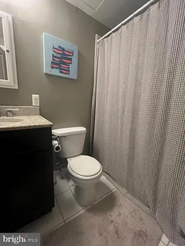 a bathroom with a toilet a sink and curtain