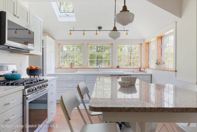 a kitchen with a stove a sink and a dining table