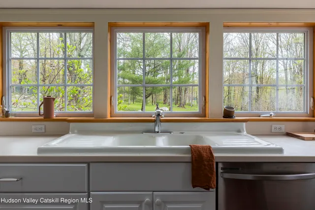 a view of a kitchen with a sink and large window