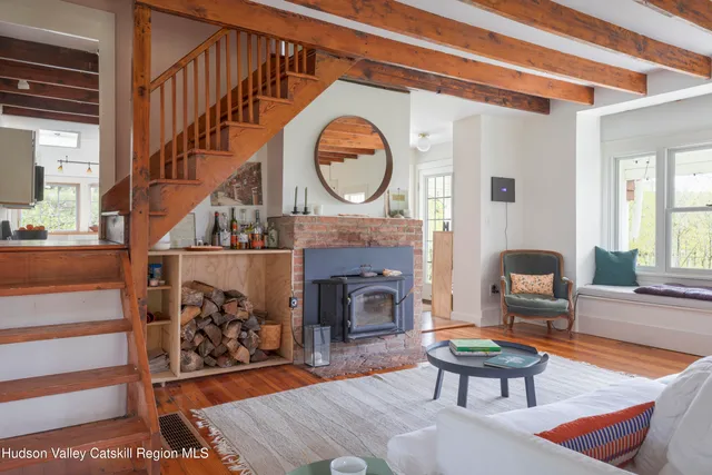 a living room with furniture a fireplace and a large window