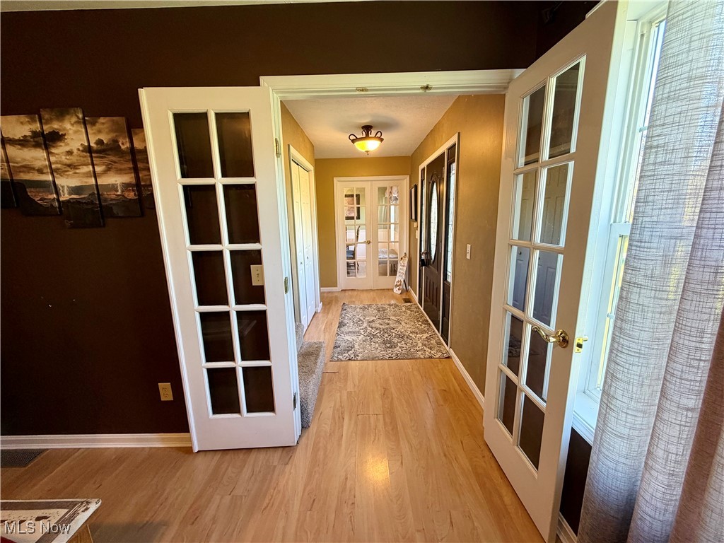 7374 Virginia Road Atwater, OH 44201 - Photo 5 of 49 Corridor with french doors and light wood-type flooring