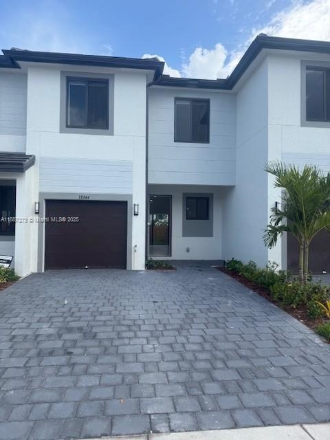 a view of a house with a yard and a garage