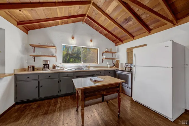 a kitchen with stainless steel appliances granite countertop a stove a sink dishwasher and a refrigerator with wooden cabinets