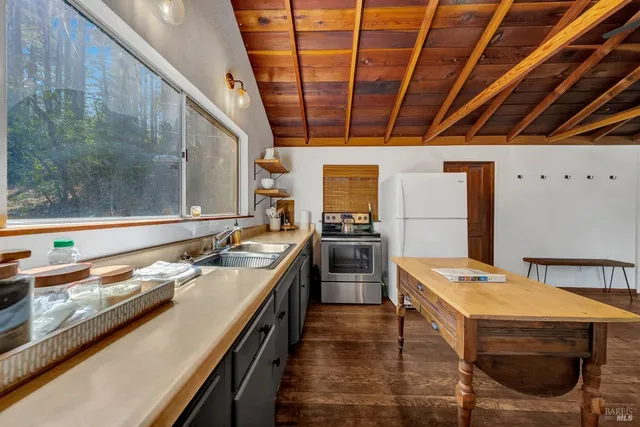 a kitchen with a sink and wooden floor