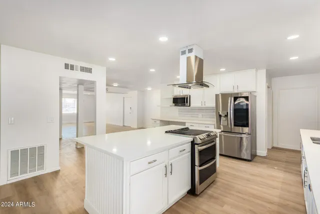 a kitchen that has a lot of counter space and stainless steel appliances