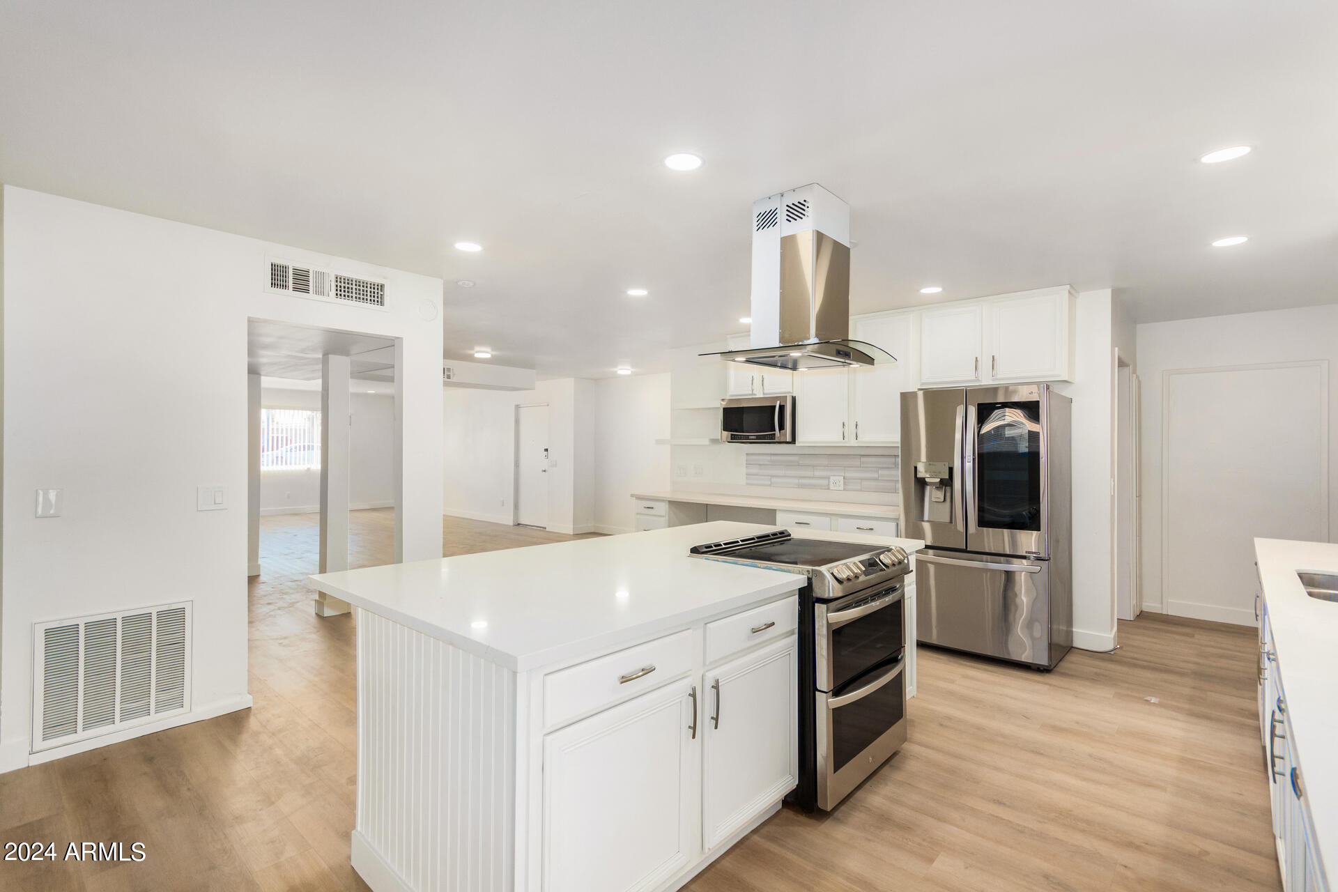 a kitchen that has a lot of counter space and stainless steel appliances